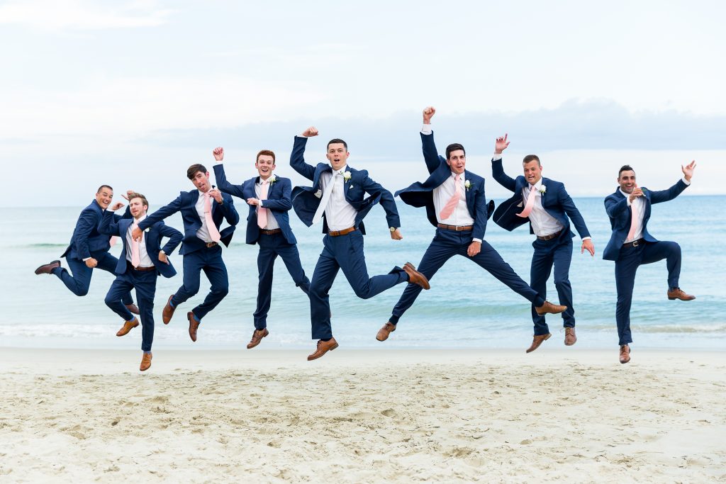 groomsmen jump for joy with the groom coordinating suits and ties knoxville nashville wedding